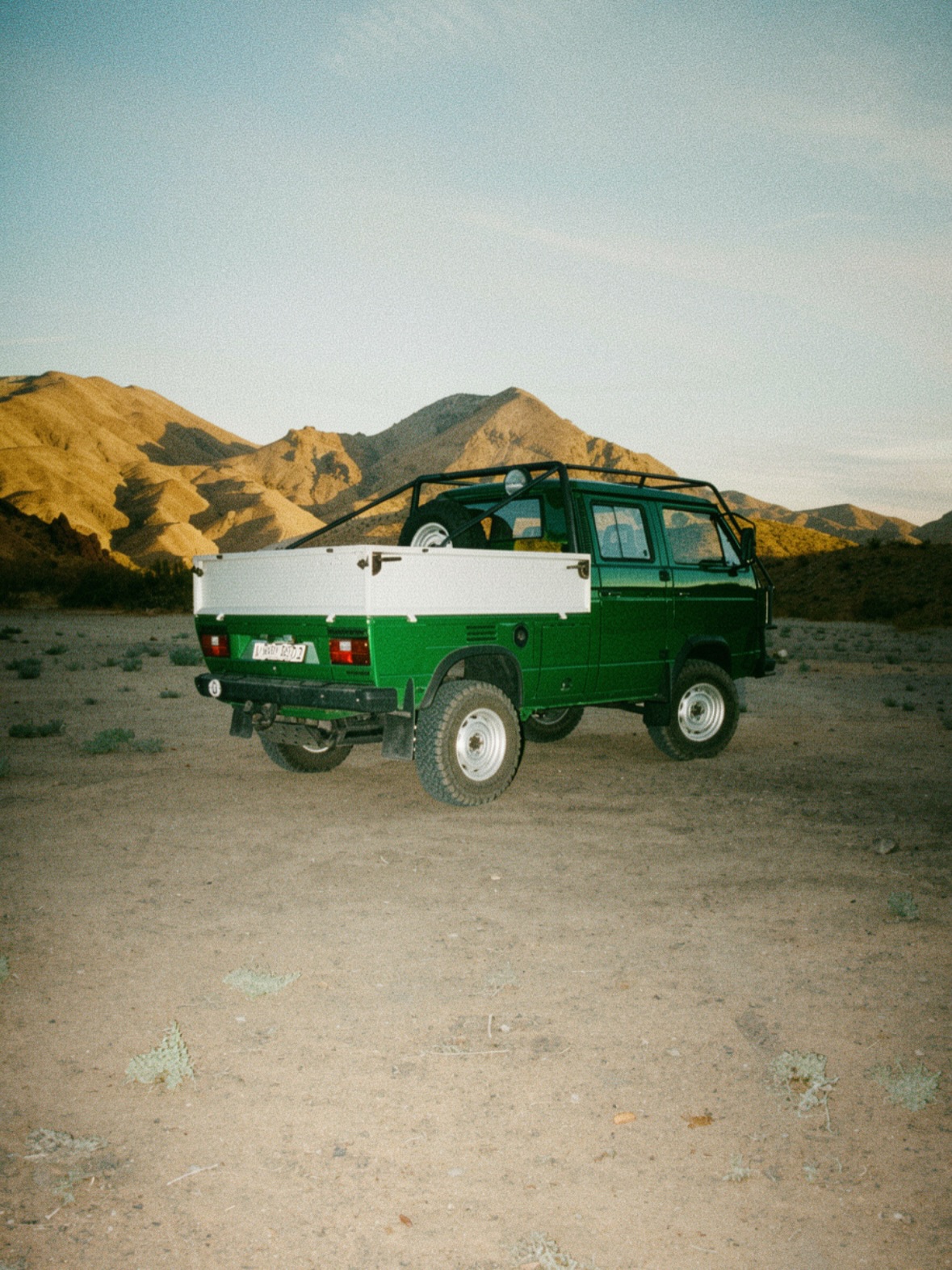 Green and white VW Doka at golden hour